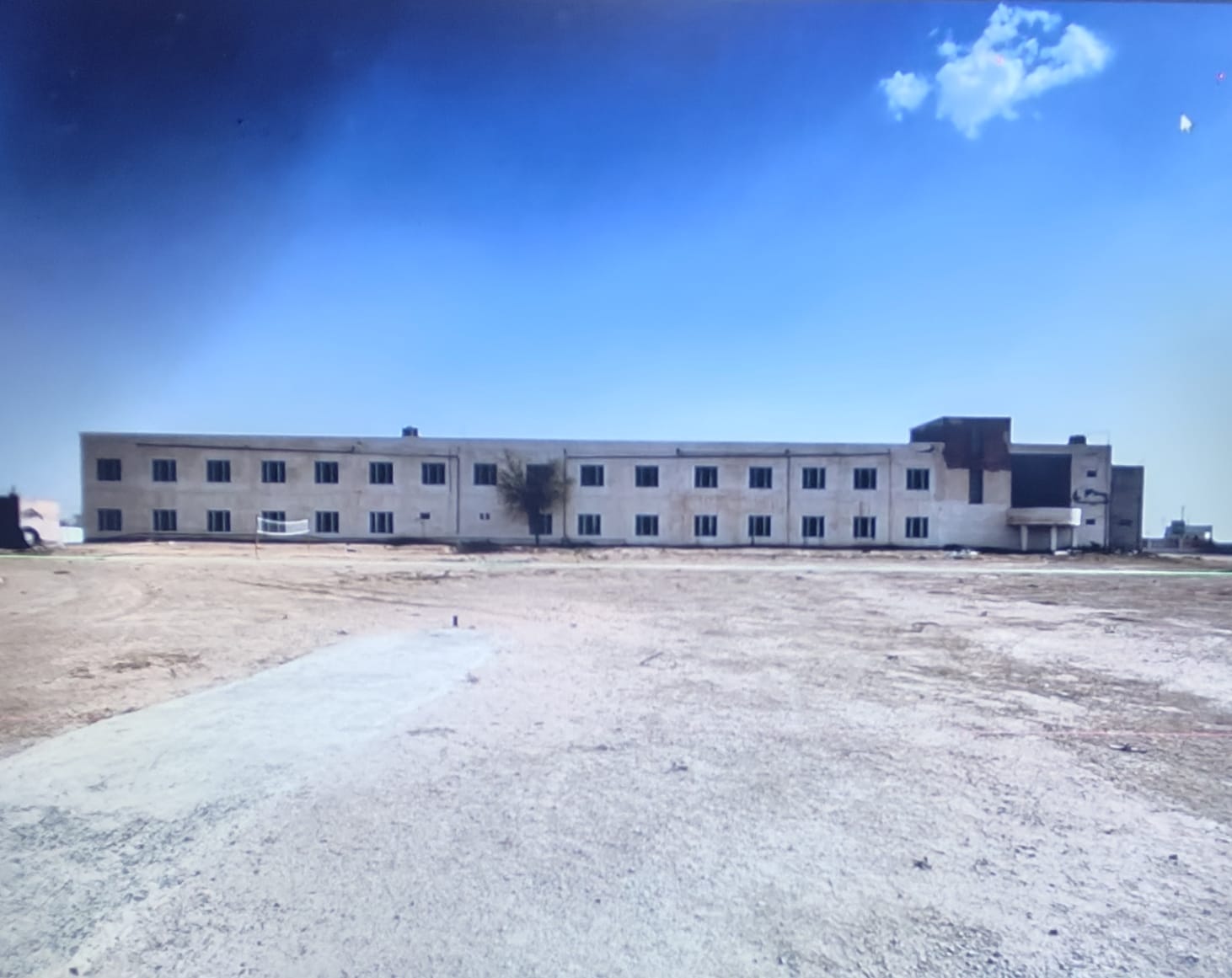 The Narain College campus building under a wide desert sky at Jhajhu