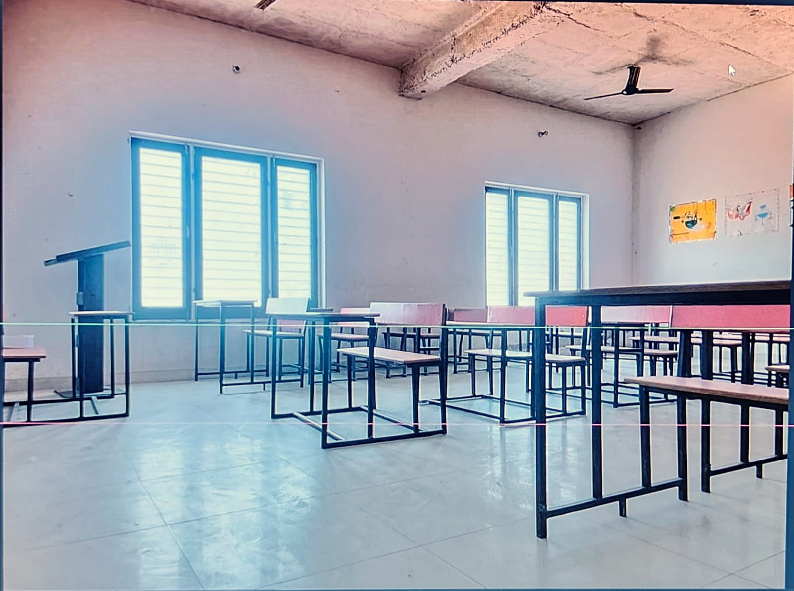 A lecture room with benches, lectern and windows along one wall