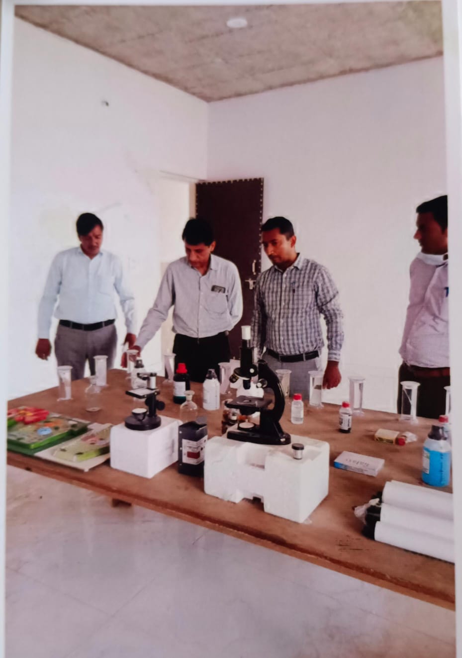 Faculty at a bench laid out with microscopes, slides and reagents